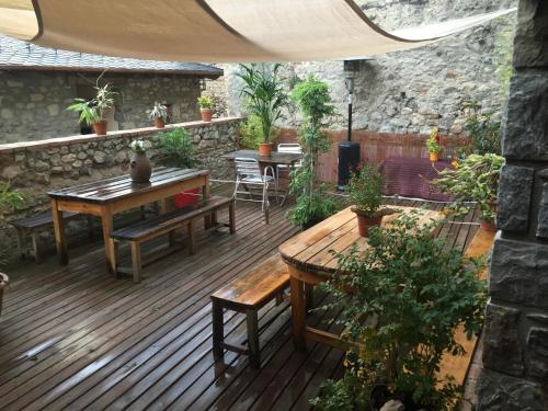a patio with tables and benches on a wooden deck at La Calma de Bellver in Bellver de Cerdanya 