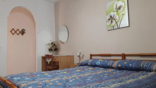 uma cama com um edredão azul num quarto em Bed and Breakfast Piazza em Sutera