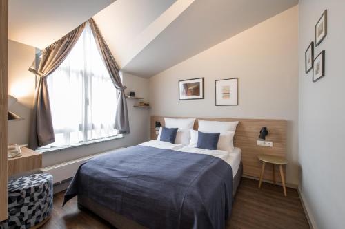 sypialnia z dużym łóżkiem i oknem w obiekcie stattHotel Weimar w mieście Weimar