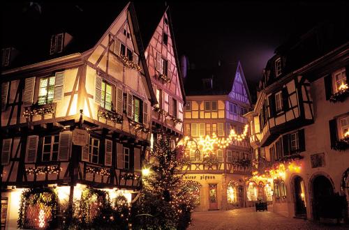 a group of buildings with christmas lights in a street at ibis Budget Colmar Centre Gare in Colmar