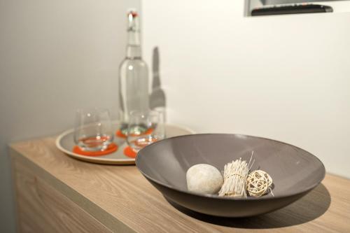 a black bowl on top of a wooden table with glasses at stattHotel Weimar in Weimar