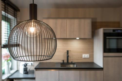 a kitchen with a pendant light hanging over a sink at stattHotel Weimar in Weimar