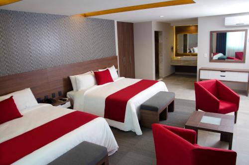 a hotel room with two beds and red chairs at Hotel 5 de Mayo in Puebla