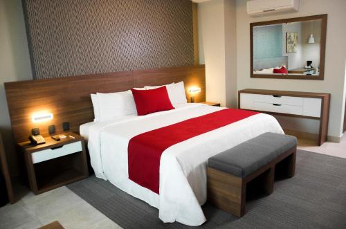a hotel room with a large bed with a red blanket at Hotel 5 de Mayo in Puebla
