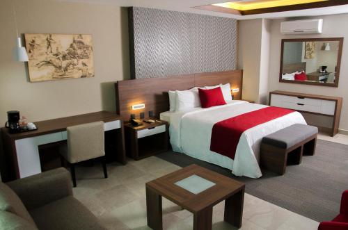 a hotel room with a large bed and a desk at Hotel 5 de Mayo in Puebla