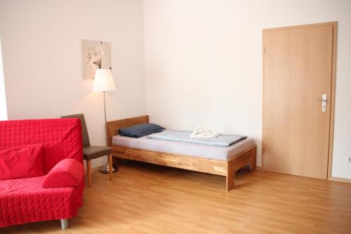 ライプツィヒにあるApartment am Zooのベッドルーム1室(ベッド1台、赤いソファ付)