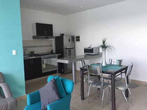 a living room with a table and chairs and a kitchen at Departamento en Dream Lagoons Cancun in Cancún