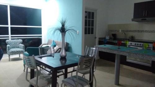 a dining room table with a vase with a plant on it at Departamento en Dream Lagoons Cancun in Cancún