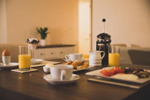 a table topped with plates of food and orange juice at Anchor House 2 East Street Alford Lincolnshire LN13 9EQ in Alford