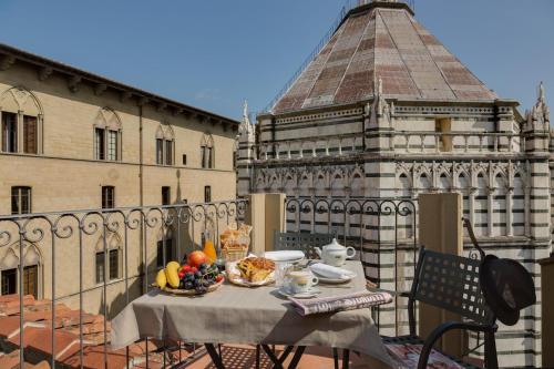 uma mesa com uma tigela de fruta numa varanda em Battistero Residenza d'Epoca em Pistoia