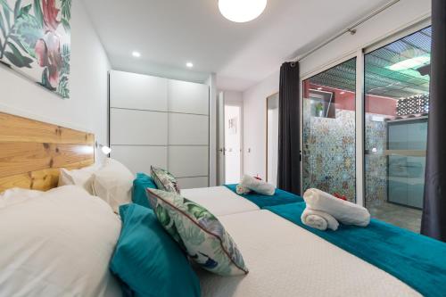 a bedroom with two beds with blue and white pillows at Bungalow en Maspalomas in Maspalomas