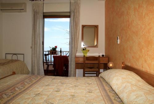 1 dormitorio con 1 cama, vestidor y ventana en Camere Santa Margherita, en Santa Margherita-Sant'Alessio Siculo