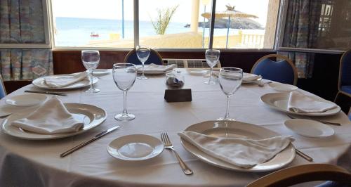 a table with plates and wine glasses on it at Bahía - 30º hotels in Puerto de Mazarrón
