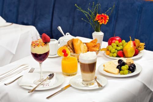 a table topped with plates of food and drinks at Mercure Hotel & Residenz Berlin Checkpoint Charlie in Berlin