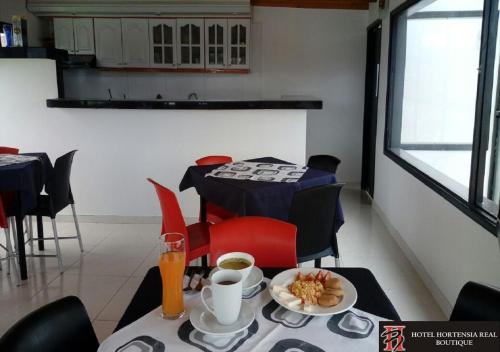 a dining room with a table with a plate of food at Hotel Hortensia Real in Paipa