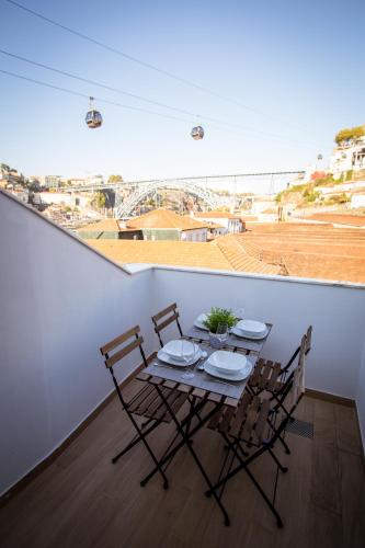 a table and chairs on a balcony with a view at Porto Views & Wines by Porto City Hosts in Vila Nova de Gaia