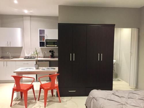 a kitchen with a table and two chairs and a cabinet at Brown Studio Apartment in Palm-Eagle Beach