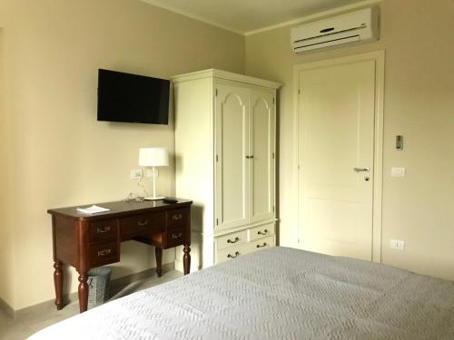 a bedroom with a bed and a desk and a cabinet at Agriturismo La Rinaldina in Faenza