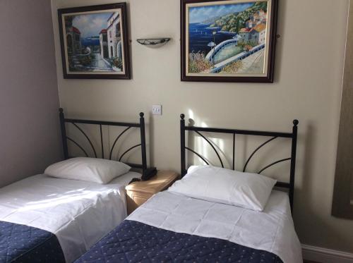 two beds sitting next to each other in a room at Central Hotel in London