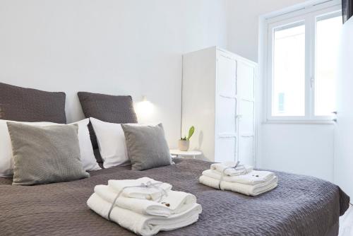 1 cama con toallas encima y ventana en Cinque Terre Luxury Apartments, en La Spezia