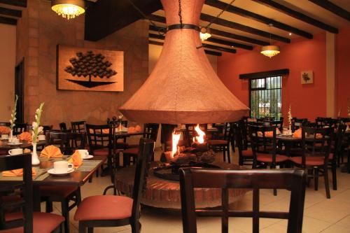 a restaurant with tables and chairs and a large chandelier at Hotel Villa Mercedes San Cristobal in San Cristóbal de Las Casas