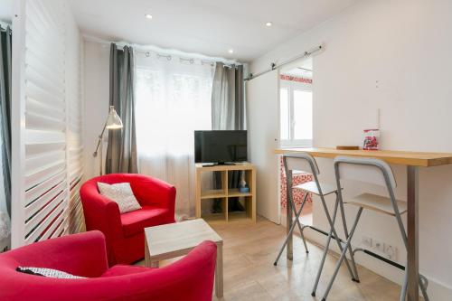 sala de estar con 2 sillas rojas y escritorio en Résidence Hôtel Le Relais Amélie, en Clamart