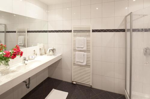 a white bathroom with a shower and a sink at Gasthof Schwarz in Mehring
