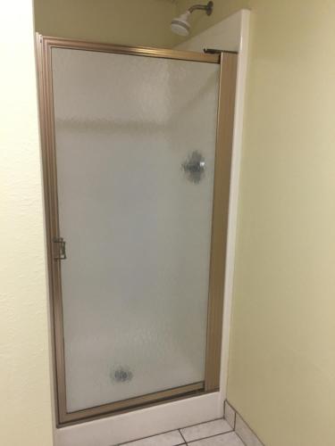 a shower with a glass door in a bathroom at Super 8 by Wyndham Newton in Newton