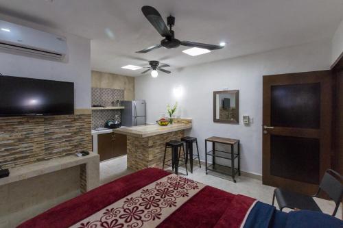 a bedroom with a bed and a kitchen with a tv at Merida Serviced Apartments in Mérida