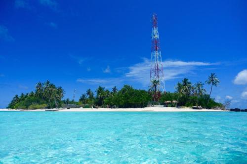 an island with a cell phone tower on a beach at Thundi Sea View in Fulidhoo