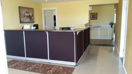 
a kitchen with a white counter top and a black counter top at Melville Country Inn in Melville
