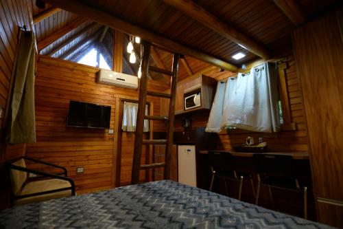 Cet appartement comprend une chambre avec un lit et une cuisine avec une table. dans l'établissement Casa na Árvore, à Santa Cruz do Sul
