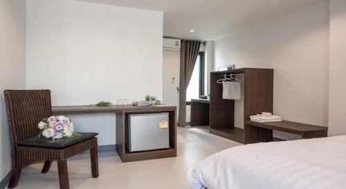 a bedroom with a bed and a desk with a tv at I Doi Hotel in Ban Pa Sang (1)