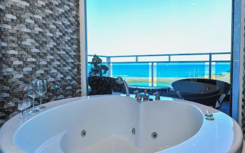 a bath tub with a view of the ocean at Sokcho Esher House Pension in Sokcho
