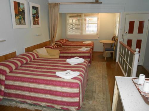 a hotel room with two beds and a couch at Mount View Motel in Bulahdelah