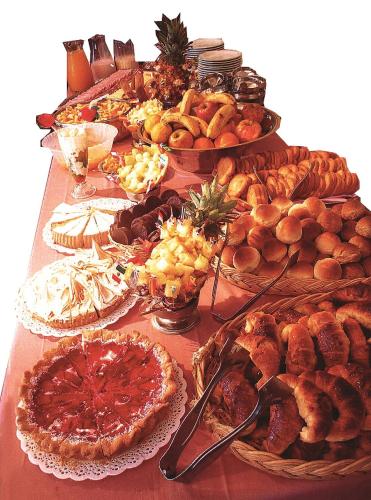 een tafel met veel verschillende soorten voedsel bij Hotel Gran International in Villa Gesell