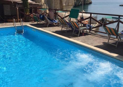 a large blue swimming pool with chairs and the water at Hotel Seggio in Vieste