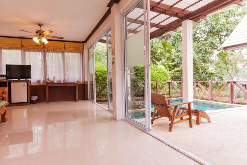 an open living room with sliding glass doors at Coco Palm Beach Resort - SHA Extra Plus in Mae Nam