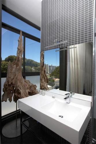 a bathroom with a white sink and a mirror at Head South Lodge in Cape Town