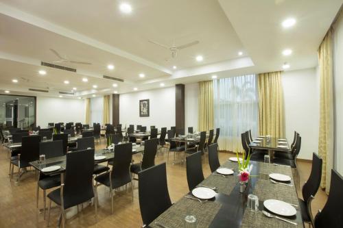 a restaurant with tables and chairs in a room at Landmark Pallavaa Beach Resorts Mahabalipuram in Mahabalipuram