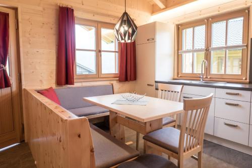 cocina y comedor con mesa y sillas en Alpenchalets Mair, en Sesto