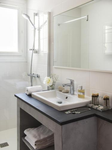 a white bathroom with a sink and a mirror at Family Golf Hotel in Royan