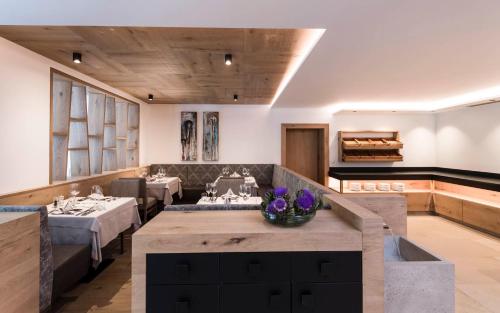 a dining room with tables and a piano at Hotel Hofbrunn in Rifiano