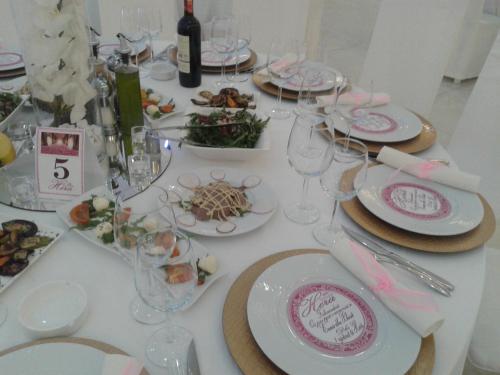 a white table with plates of food and wine glasses at Hotel Green in Tirana