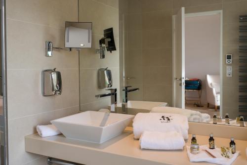 y baño con lavabo y espejo. en Château & Spa de la Cueillette en Meursault