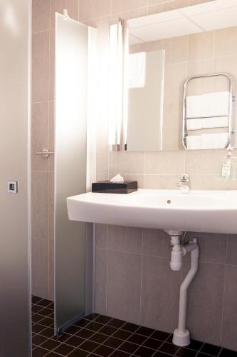a bathroom with a white sink and a mirror at Best Western Kom Hotel Stockholm in Stockholm
