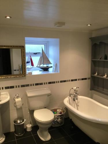 a bathroom with a tub and a toilet and a sink at Weardale Cottage in Saint Johns Chapel