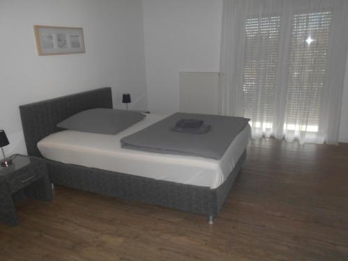 a large bed in a bedroom with a wooden floor at Hotel Sonnenhof in Sindelfingen