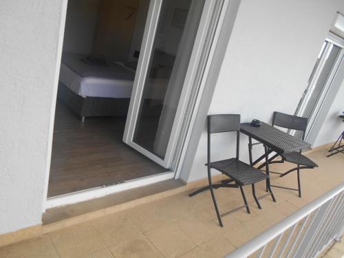 a balcony with two chairs and a table and a bed at Hotel Sonnenhof in Sindelfingen