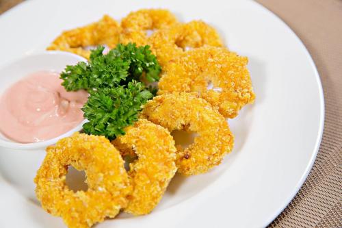 a plate of food with fried onion rings and dipping sauce at Bella Rosa Hotel & Travel in Hanoi